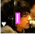 A pixelated image of a person with dark hair and light skin, wearing a beige garment, overlaid with pink text that changes across frames.