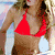 A 4-frame animated contact sheet showing a woman in a red bikini top against a beach background with ocean and sky, displaying subtle pose and expression changes across frames.