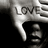 Pixelated grayscale image of a hand pointing downward with 'LOVE' text above it, set against a dark background.