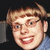 Pixelated image of a person with light brown hair and glasses, wearing a blue shirt against dark background with text "How you doin baby" on right.