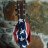 Pixelated image of a figure holding a guitar with red and blue accents against a blurred background.