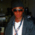 A person wearing a dark cap, sunglasses, white shirt, and dark jacket with blue lanyard appears in three showing slight variations
