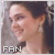 Pixelated close-up of a person's face with dark hair tied back, wearing small earrings and light-colored clothing, with 'FAN' text in the bottom-left corner.
