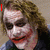 A four- shows a character with messy brown hair, white face paint, and red lips smiling; the right has a red arrow on the cheek