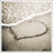 A beach scene with a heart drawn in sand, the word 'LOVE' written inside it, and waves washing over the drawing.
