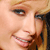 Pixelated close-up of a person's face showing eyes, nose, mouth, and hair with visible teeth in a smile.