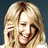A blonde woman appears in three distinct poses: smiling with hand near face, holding microphone, and standing before floral backdrop.