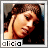 A pixelated portrait of a person with brown hair, wearing a dark top, with the name 'alicia' displayed below in pixelated text.