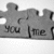 Pixelated grayscale image of a figure with outstretched arms holding a sign reading 'you me' against a light background.