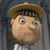 Pixelated cartoon character with large eyes, brown cap, and light skin, wearing a striped shirt against a dark background.