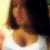 Pixelated close-up of a person with brown hair and light skin, wearing a white top, against a bright yellow background.