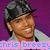 Pixelated image of a person wearing a dark cap and light shirt against purple background with pink text overlay.