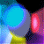 A 2x2 contact sheet of four animated frames showing a colorful abstract animation with glowing circular shapes and geometric forms in blue, yellow, pink, and purple hues against a black background.