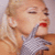 A pixelated image of a woman with blonde hair and red lipstick holding a gray glove near her mouth, next to bold white text on a black background reading "Gwen Stefani Fall!!".