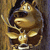 A pixelated golden figure with a crown, holding a sword and shield, set against a brown background with a dark blue border.