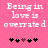 Pink background with white pixelated text reading 'Being in love is overrated' and five heart symbols below, where the third heart changes color from dark purple to black between frames.