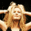 A pixelated image of a person with long blonde hair in four showing different poses and expressions, including arms raised above the head and a spiral symbol