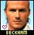 Pixelated portrait of a man with light skin and short hair, wearing a white shirt against a blue gradient background with a heart symbol.