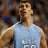 Pixelated image of a person in light blue sleeveless shirt with white numerals, standing against blurred background.