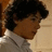A split-screen image with a red background, featuring a person in a white shirt on the left and pixelated text on the right.