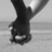 Black-and-white image of a person's lower legs and feet in motion, with two text overlays showing different names.