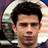 Static 48x48 pixel icon showing a close-up of a person's face with dark hair, wearing sunglasses and a blue-and-white striped shirt against a blurred background.