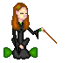 Pixelated witch avatar with long brown hair, green eyes, and a small green flower on her head, wearing black robes with green accents while holding a wooden wand.