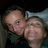 Two people pose closely together in a pixelated image with overlaid text and symbols on a black background.