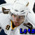 Pixelated hockey player in white jersey with brown and yellow accents, another in dark jersey with orange and white accents, and a third in blue uniform with green headgear.