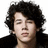 A person with curly dark hair and a black jacket appears in three views showing slight head position shifts against white backgrounds.