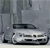 Pixelated grayscale image of a vehicle with visible headlights and front grille, set against a blurred background with vertical elements.