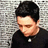 A pixelated image shows a person with short dark hair wearing a black shirt against a gray textured background, with blue text reading 'billie joe' on a red background.