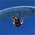 Pixelated icon of a person in mid-air with parachute gear against blue sky and water background.