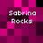 Pixelated image with four instances of 'Sabrina Rocks' text on a magenta and black checkered background.