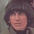 Pixelated close-up of a person with dark hair and light skin, showing facial features against a muted background.