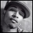 Black-and-white pixelated static image of a person wearing a wide-brimmed hat, viewed from the side with visible facial features including eyes and mouth.