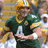 Pixelated image of two football players in green and yellow uniforms with helmets, one holding a trophy.