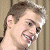 A pixelated image of a person with short brown hair smiling, next to green text reading 'Original Icons .com' on a dark background.