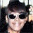 25 identical cartoon-style portraits showing a person with dark sunglasses, smiling broadly, and wearing a black top against a light background