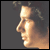 Pixelated static image of a person's face in profile view with warm lighting and dark background.