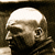 Pixelated grayscale image of a human skull in profile view, showing the right side with visible eye socket and nasal cavity against a dark background.