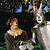 A pixelated image shows a light brown horse with a white mane standing beside a white horse with a dark mane, both facing left against a dark background with blue and green accents.