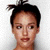 Static pixelated image of a person with dark hair tied in a small topknot, light skin tone, and neutral expression against plain background.