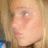Pixelated close-up of a person's face with light skin tone, visible eye and nose, and blonde hair strands on the left side.