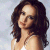 Pixelated image of a woman with long dark brown hair wearing a white sleeveless top against a light blue background.