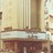 Pixelated static image of a building facade with vertical columns and a horizontal band, rendered in muted beige, brown, and light blue tones.