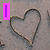 A static image shows a heart drawn in sand with a pink vertical bar on the left, two hearts drawn in wet sand near water, and a purple neon-style heart with yellow 'love' text.
