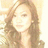 Pixelated close-up of a person with long light brown hair against a bright background, showing partial facial features and shoulder-length strands.