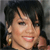 A pixelated close-up of a person with short dark hair, light skin, and a gold hoop earring, smiling with visible teeth against a dark background.