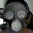 A gas mask-wearing figure with headphones appears in six , each displaying different text overlays